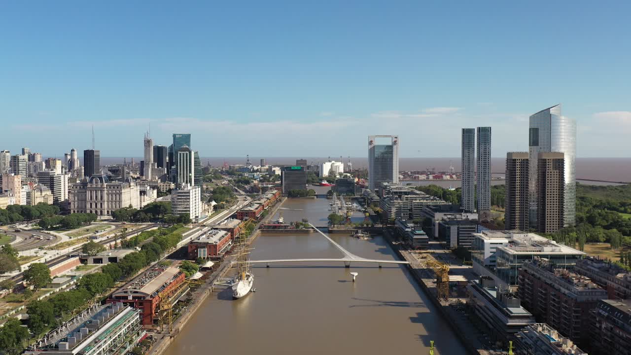 The Buenos Aires skyline unfolds along the river, showcasing iconic structures and the Woman's Bridge