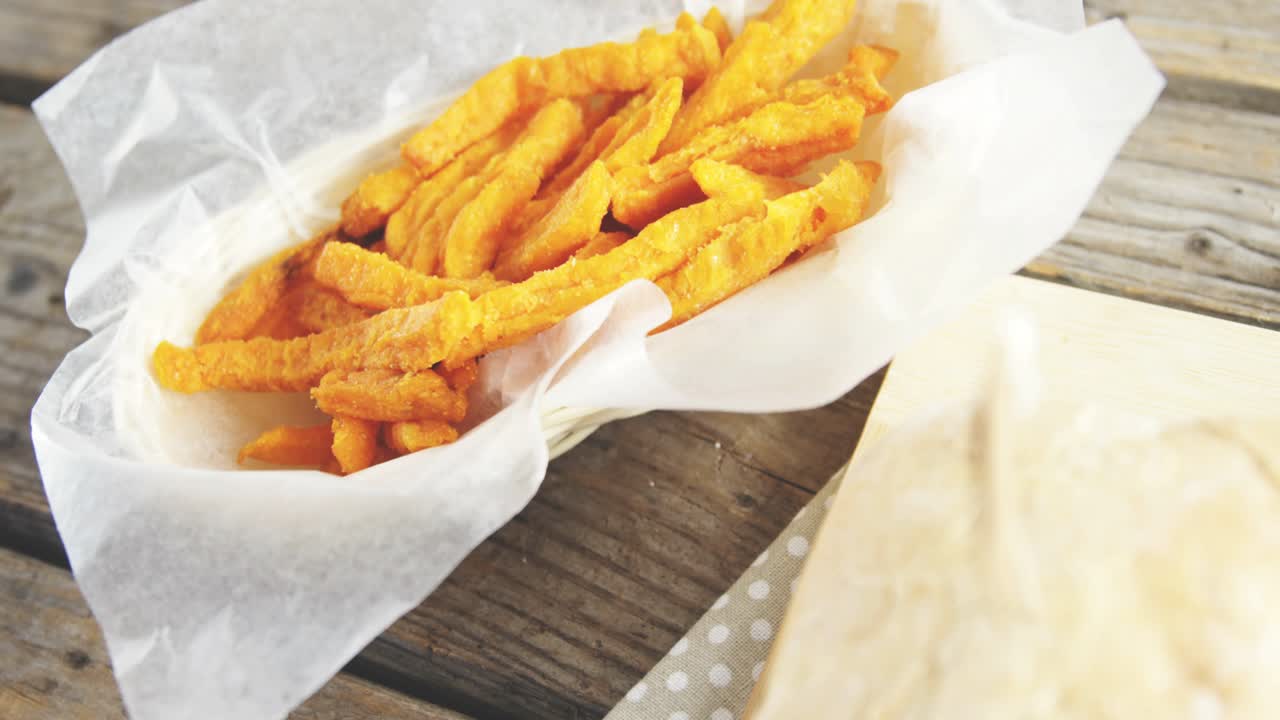 Explosión de una pequeña burbuja azul, aumento de los contadores que muestran interés mientras la cámara se mueve hacia un sándwich y unas patatas fritas