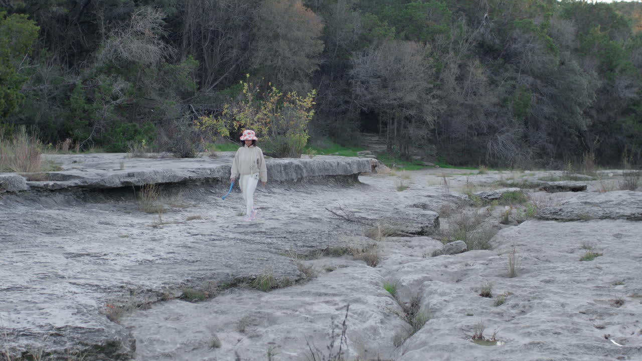 девушка гуляет и гуляет на высушенном русле реки на открытом воздухе