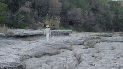 Chica-Caminando-Y-Haciendo-Senderismo-En-El-Lecho-De-Un-Río-Seco-Al-Aire-Libre