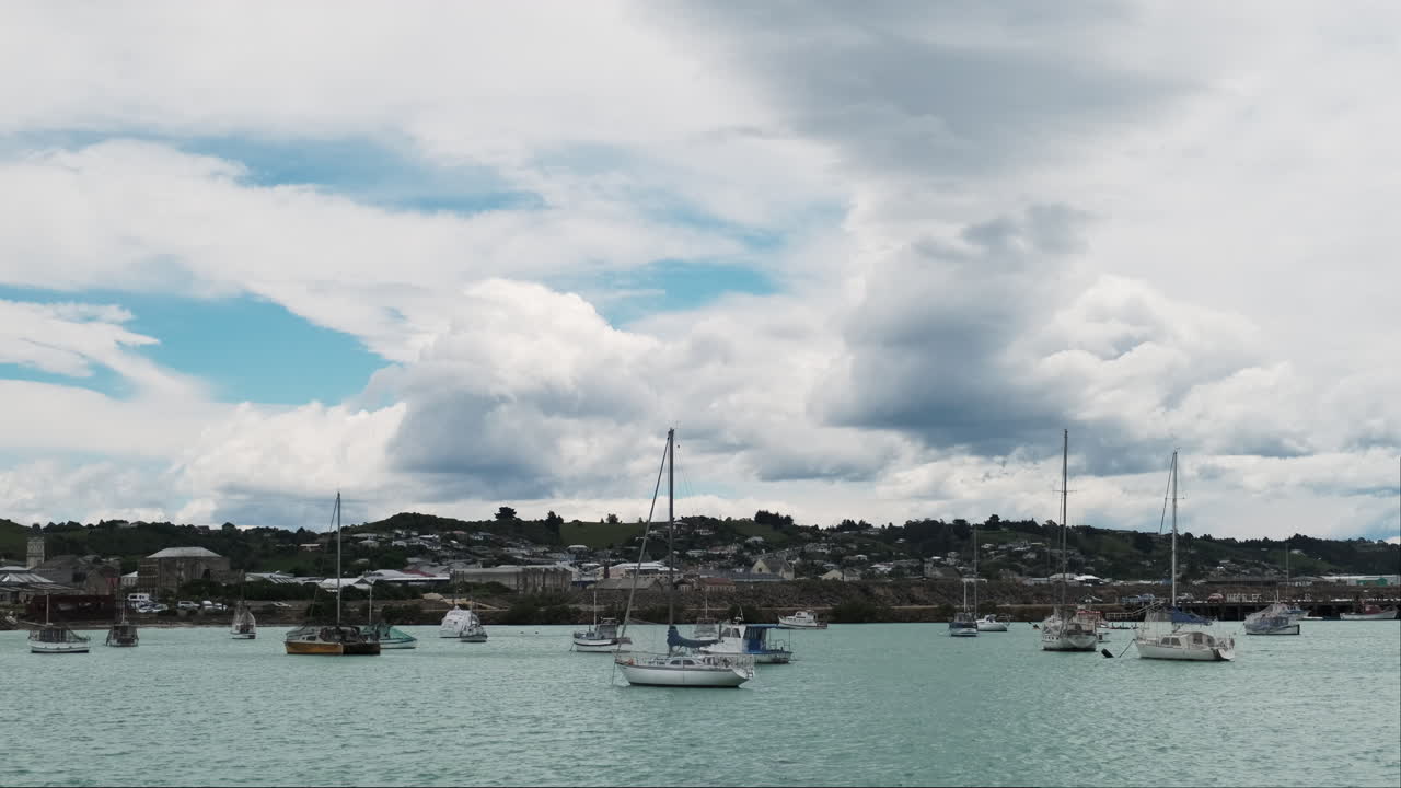 ⁇ 은 물과 부분적으로 구름진 하늘을 가진 평화로운 마리나에 정박한 세일보트
