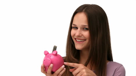 una mujer poniendo dinero en una alcancía.