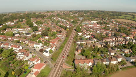 descending aerial shot of london underground train leaving epping town