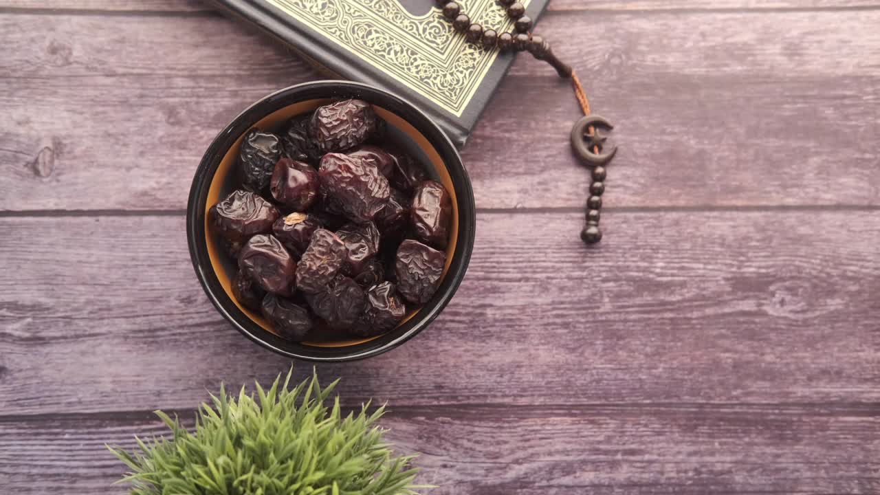 libro sagrado corán, cuentas de oración y frutas de dátiles en la mesa con espacio para copiar