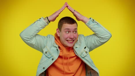 man playing childish catching up game, feeling in safe making roof above head with hands, insurance