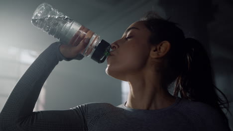 sportswoman drinking water from sports bottle. girl holding bottle in hand