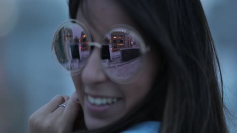 joven posando con grandes gafas de sol redondas y divertidas