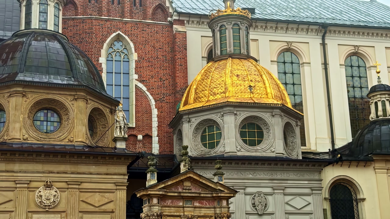 Close-up of Wawel Cathedral’s gilded dome and ornate chapels in Krakow, Poland, highlighting historic stonework, arches, and Renaissance details on a cloudy day.