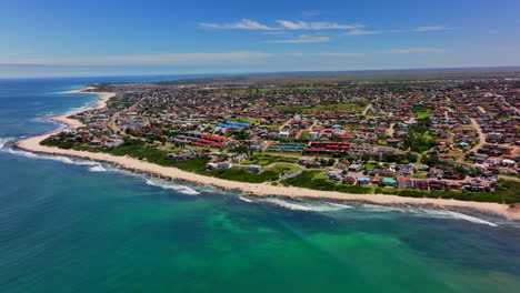 áfrica del sur jbay jeffreys bay avión no tripulado ciudad casa edificios más impresionantes playa de arena blanca épica ola de surf acuático azul escarpado arrecife costa durante el día wsl corona abierto supers boneyard verano marcha atrás