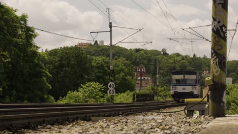 vías de tren que pasan por un área parecida a un parque en una ciudad