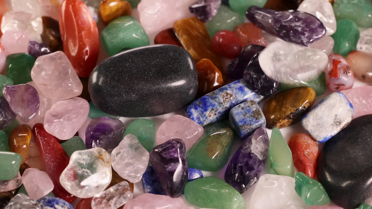 Vibrant chakra stones rotate, showcasing diverse colors and textures in a dynamic, well-lit environment