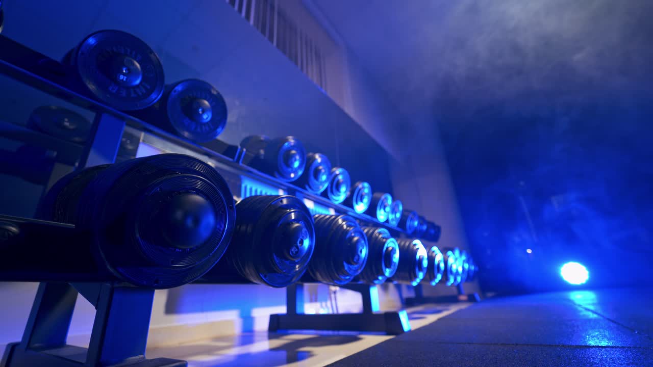 Gym interior with equipment. View of rows of dumbbells in the gym