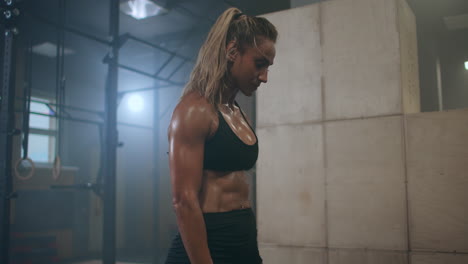 fatigue and exhaustion. a strong woman is breathing heavily and recuperating after cross training. perspiring drops of sweat.