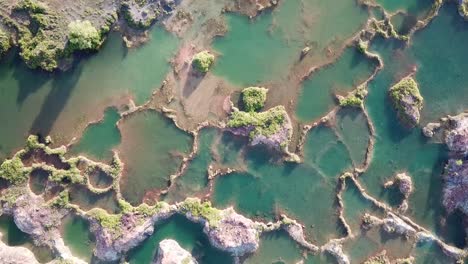 Aerial-view-hidden-gem-blue-quarry-surrounded-by-red-cliff