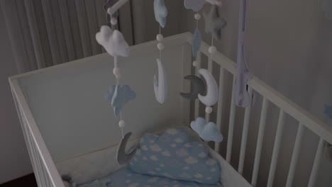 cozy crib with a celestial themed mobile featuring clouds, moons, and stars, creating a serene and comforting nursery environment