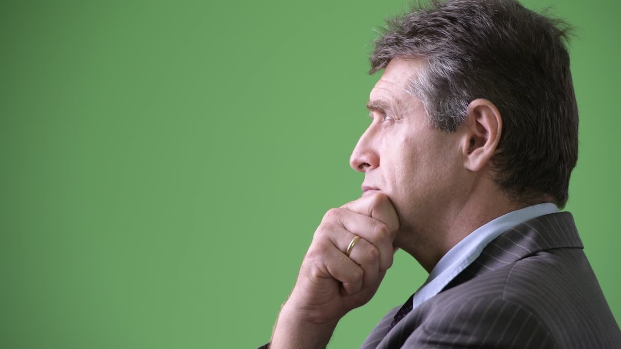 hombre de negocios maduro y guapo contra un fondo verde