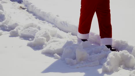 santa is walking along the snow path