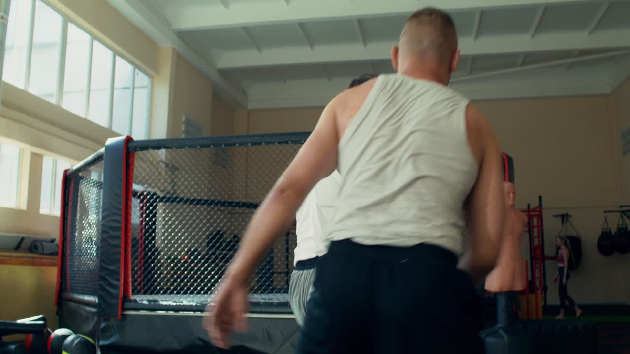 MMA-kæmpere i clinch i buret
