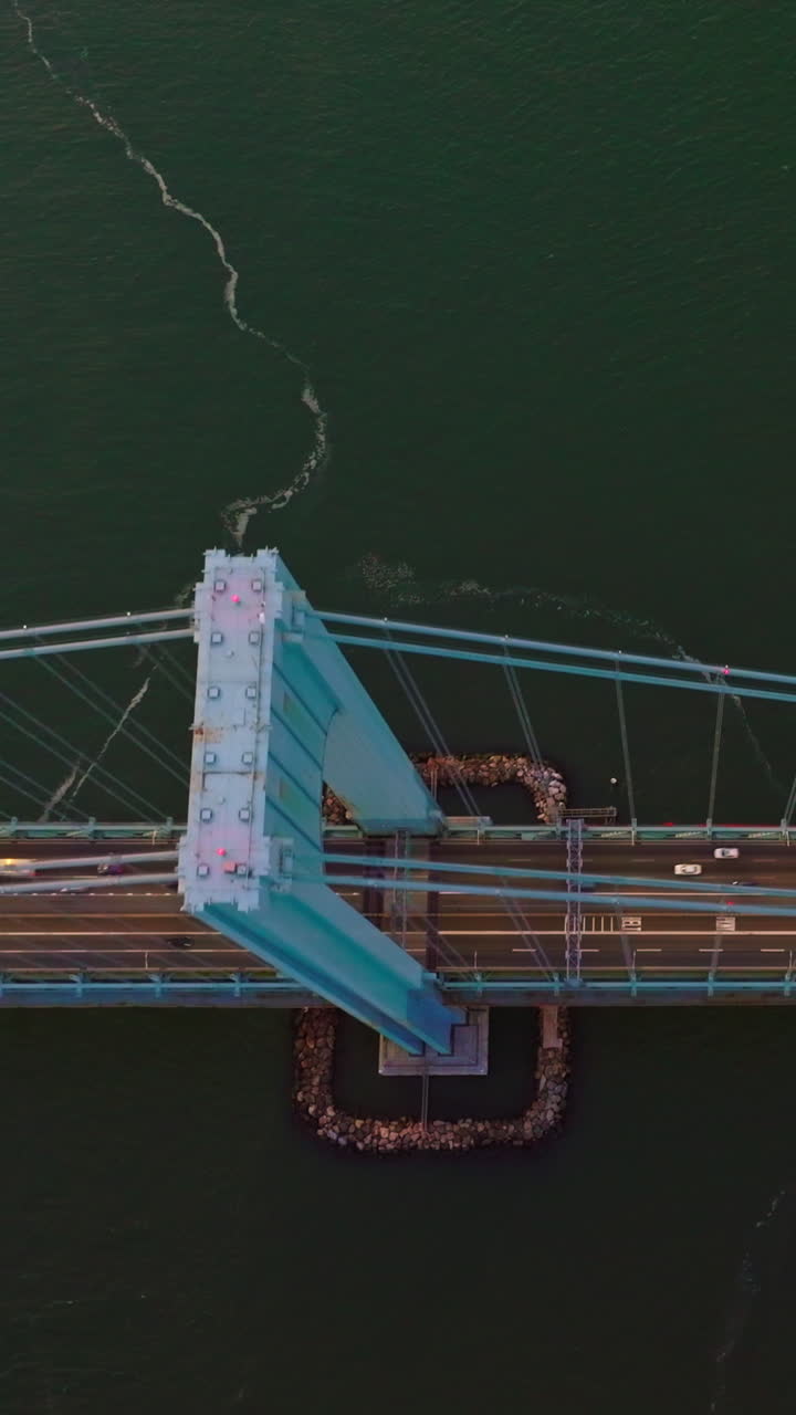The Bronx-Whitestone bridge over the East River. Flying high above the bridge construction with cars passing through it. Vertical video