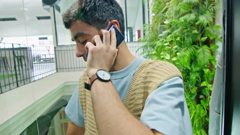 Young Man Speaking on Phone in Office Elevator