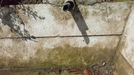 tubería de la cuenca de agua goteando agua lentamente durante el calor del verano - vista frontal