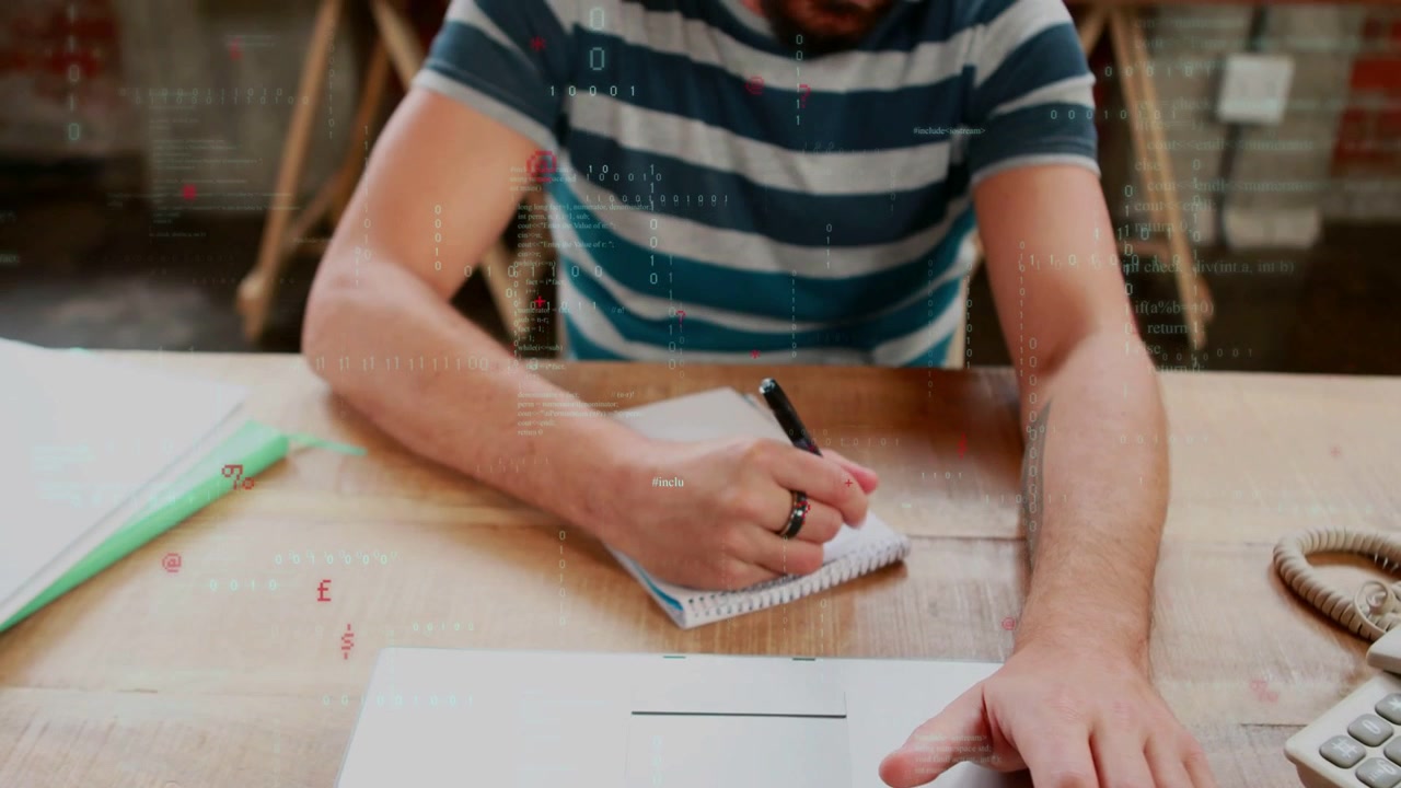 Uomo che digita, si ferma per prendere una penna e prendere appunti alla scrivania, con animazioni sul blocco note del portatile.