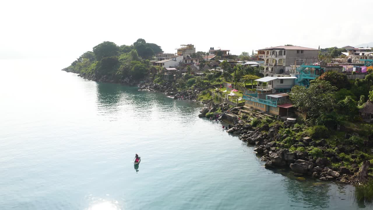 과테말라 에 있는 아틀란 호수 해안 에서 작은 배 나 카누 를 타고 홀로  ⁇ 시 를 하는 사람