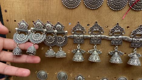 hand of a girl looking at handmade earrings for sale in the shantiniketan in west bengal, india