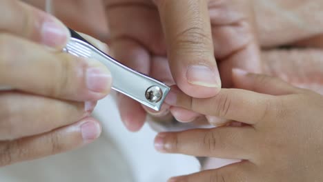 a caregiver gently clips a child's nails promoting safe grooming habits a nurturing home setting