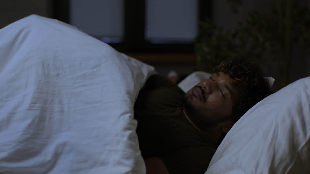hombre durmiendo en la cama por la noche
