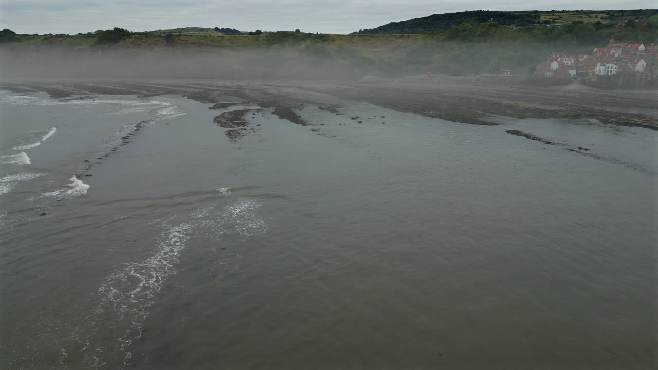 Long Rising Establishing Aerial Drone Shot of Robin Hood's Bay in Mist at Low Tide