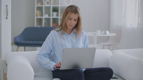 mujer de negocios enfocada empresaria escribiendo en una computadora portátil haciendo investigación. mujer joven profesional usando la computadora sentada en el escritorio de la oficina en casa. trabajadora ocupada profesional independiente trabajando en un dispositivo de portátil de tecnología moderna