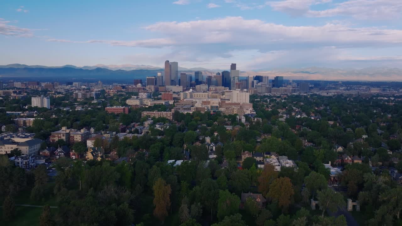 Ripresa aerea che sorvola i quartieri di Denver verso lo skyline del centro, con un'ampia panoramica in tilt-up.