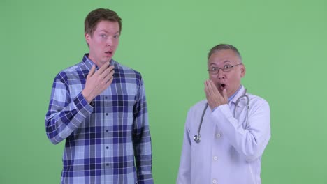fotografía de estudio del médico y el paciente mirando sorprendidos y conmocionados contra un fondo verde