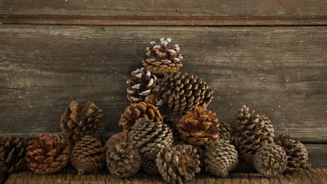 animation of snow falling over pine cones on wood boards