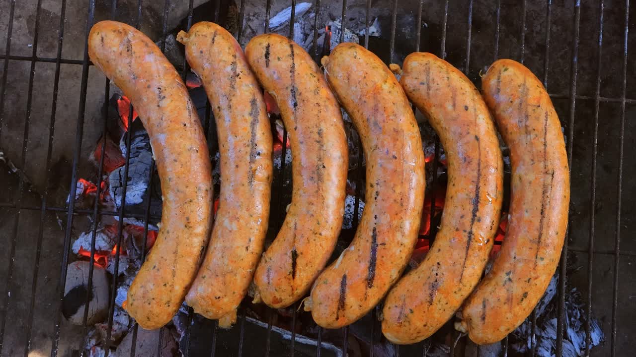 Läckra saftiga korvar, tillagade på grillen över öppen eld.