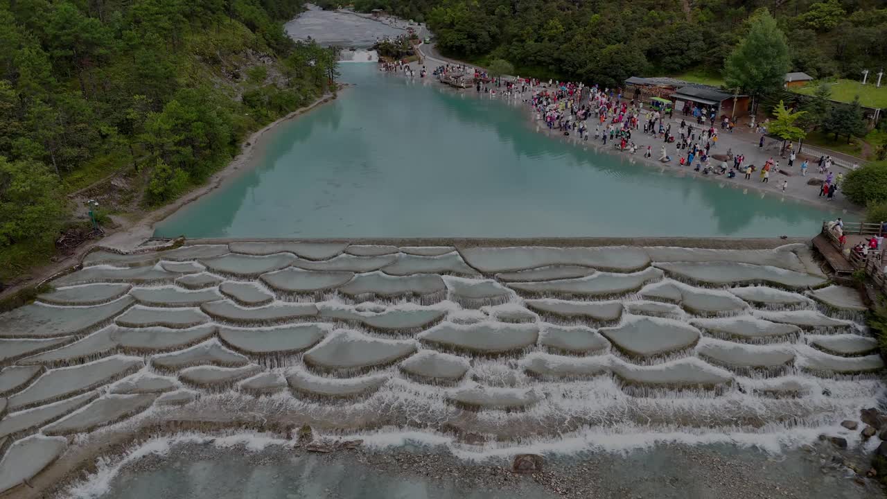 Drone slowly landing over blue moon valley lake in Yunnan province