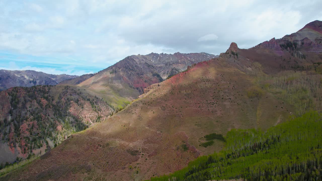 Telluride Colorado USA. Aerial Drone Shot Of Rocky Mountains Alpine Mountain Ridge With Green Foliage And Natural Red Rock With Cloud Shadows Moving On The Face Of The Mountain
