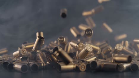 Numerous-Spent-Bullet-Casings-Falling-in-Pile-with-Drifting-Smoke