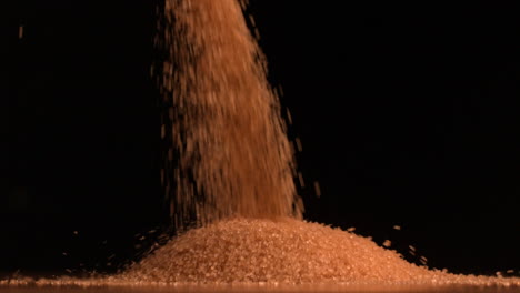 golden sugar pouring on black background