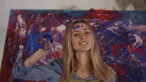 Tired-female-painter-after-finishing-her-masterpiece-in-art-studio