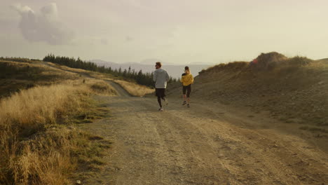 athletes running on road in mountains. couple doing cardio workout outdoor