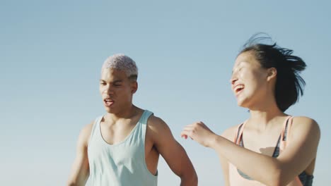 Happy-biracial-couple-running-on-promenade,-in-slow-motion