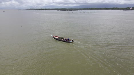 Small-boat-with-fishermen-floating-around-island-in-Thailand