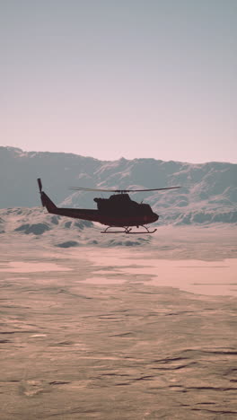 vintage american military helicopter at sunset on icy terrain