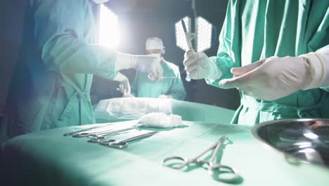 diversos cirujanos que utilizan instrumentos quirúrgicos en el quirófano del hospital, en cámara lenta