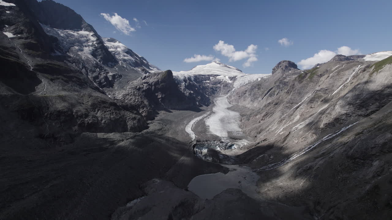 vista panorámica del glaciar pasterze con el macizo grossglockner y el pico johannisberg, paisaje glaciar en retirada cubierto de morrena debido al calentamiento global