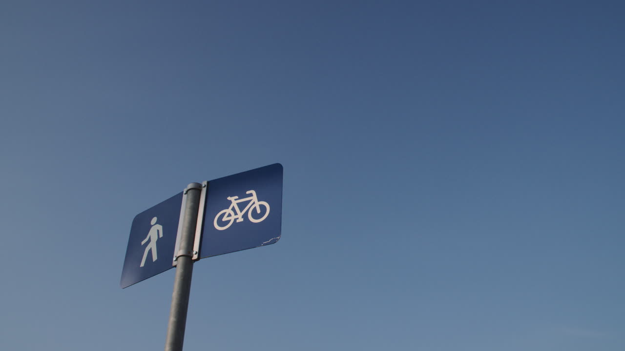 Prise de vue à main levée d'un panneau de piste cyclable sur fond de ciel bleu