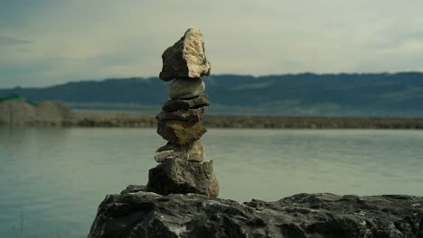 balancing stone with lake and mountain in the background