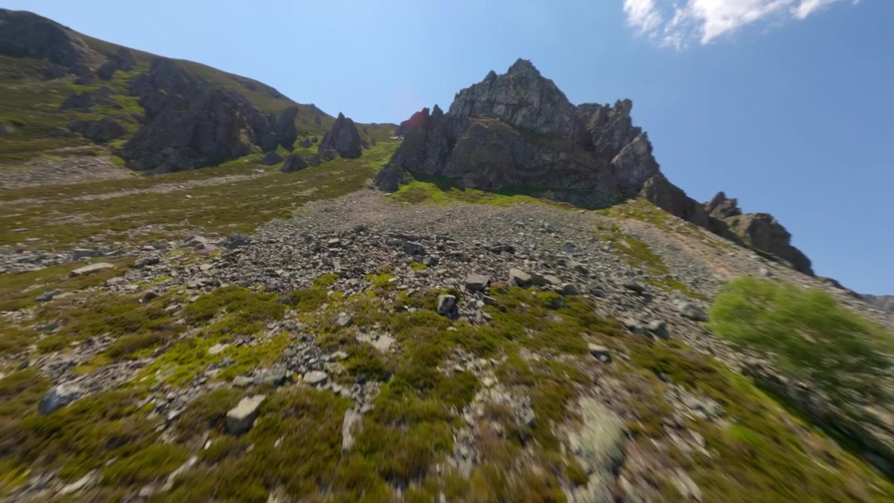 Video dinamico FPV con drone che si libra su pendii rocciosi scoscesi e creste erbose della Cordigliera Cantabrica in pieno giorno, catturando texture drammatiche, cime aguzze e una vasta bellezza naturale.